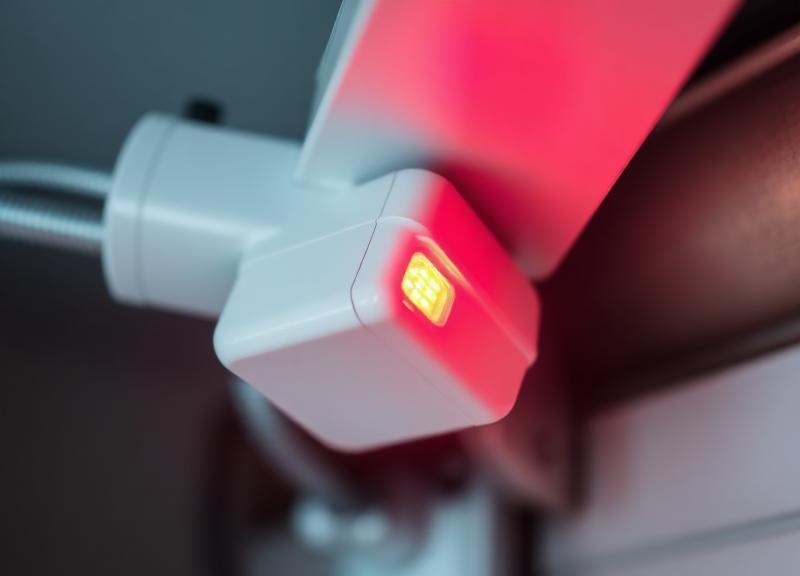 Professional technician calibrating garage door safety sensors on a craftsman style door